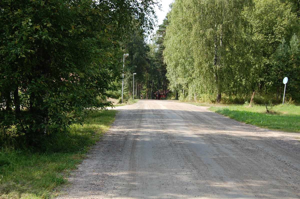 Kuhnamontietä saunanrannan suuntaan. Kuvan vasemmalla puolella oli ennen talvisin luistinrata. Se toimi kesäisin pallokenttänä. Kuvan oikeassa reunassa liikennemerkin takana oli yhtiön vesiposti, josta käytiin juomassa vettä urheilurientojen lomassa.