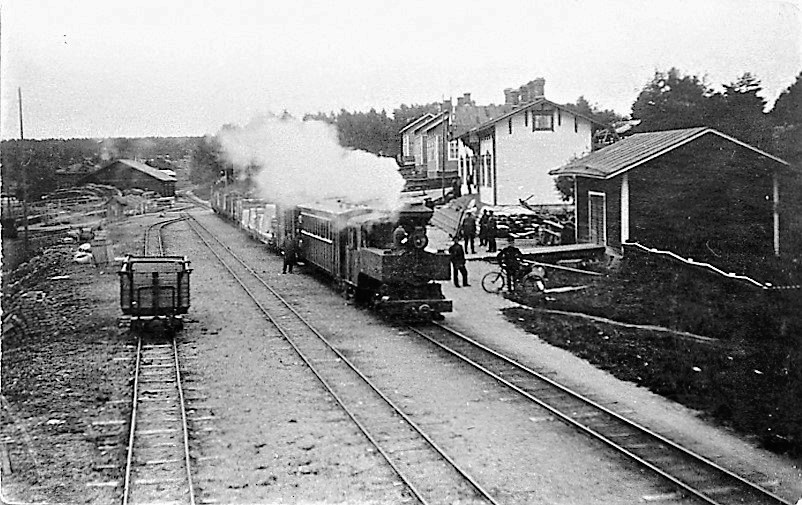 Äänekosken-Suolahden välinen kapearaiteinen rautatie ns. Pässinrata valmistui vuonna 1900. Ratalinjan pituus oli 9,25 km, minkä lisäksi pääteasemilla oli sivuraiteita runsas kilometri. Radan Äänekosken  päähän, Hiskinmäen asuntoalueen eteläpuolelle rakennettiin heti vuosisadan alussa Äänekosken ensimmäinen rautatieasema. Kuvassa juna lähdössä Äänekosken asemalta. Asema on junan oikealla puolella oleva valkoinen rakennus. Taustalla Hiskinmäen asuntoalueen taloja. Asemarakennus jouduttiin myöhemmin siirtämään paikaltaan Suolahti-Haapajärvi radan rakentamisen aikana.
