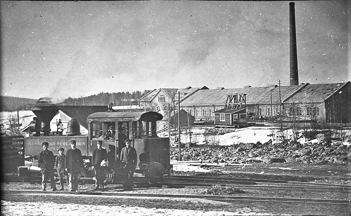 Pässi miehistöineen Äänekosken rautatieasemalla. Taustalla vanhan kartonkitehtaan ja vanha  höyryvoimalaitoksen rakennukset. Kuva on aivan 1900-luvun alkupuolelta, koska siinä ei vielä näy vuonna 1926 rakennettua uuden höyryvoimalaitoksen 78 metristä savupiippua.