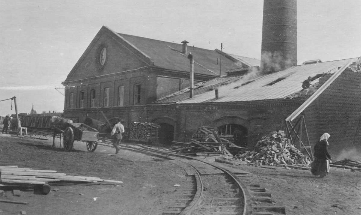 Tehtaiden höyryvoimalaitoksen käyttöön valmistui vuonna 1925 uusi 78-metrinen savupiippu ja sitä seuraavana vuonna saatiin voimalaitokselle käyttöön kaksi uutta Babcock-Wilcox -valmisteista höyrykattilaa. Kuvassa voimalaitoksen laajennuksen sivuseinää ja kattoa ollaan rakentamassa, joten se allakoitunee näin ollen 1920-luvun lopulle. Takana näkyvä harjakattoinen rakennus on kartonkitehtaan kiinteistö. Varsinainen kartonkinone apulaitteineen sijaitsi rakennuksen alakerrassa ja ylemmässä kerroksessa oli pakkasali, jossa tuotanto punnitttiin ja lajitteltiin. Etualalla näkyvä rautatietä on palvellut tehtaiden tuotantoa sekä voimantuottoa.