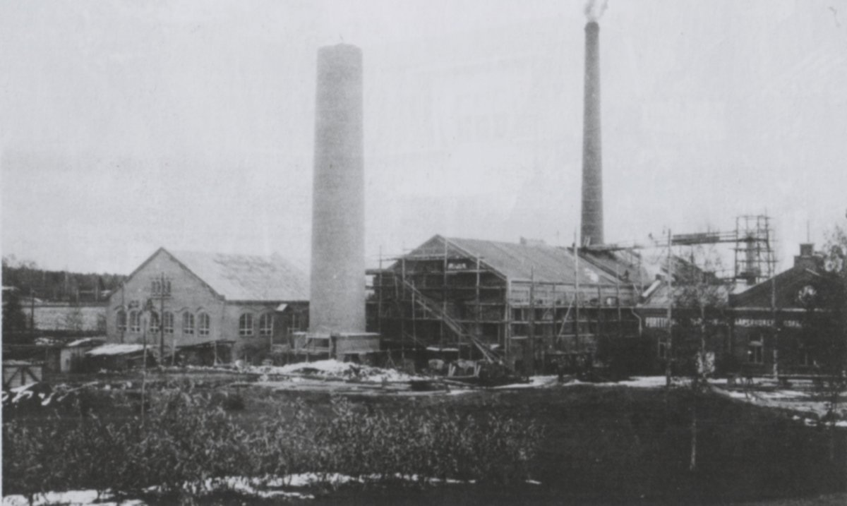 Tässä 1920-luvun lopulle allakoituvassa kuvassa höyryvoimalaitoksen laajennus on rakenteilla. Uuden 78-metrisen savupiipun muuraus on aluillaan. Käsin valmistetun puupahvin valmistus kävi kannattamattomaksi, josta syystä sen valmistus lopetettiin. Ilmeisesti tähän liittyen myös korkea kuivauskanaali kävi tarpeettomaksi ja se purettiin.