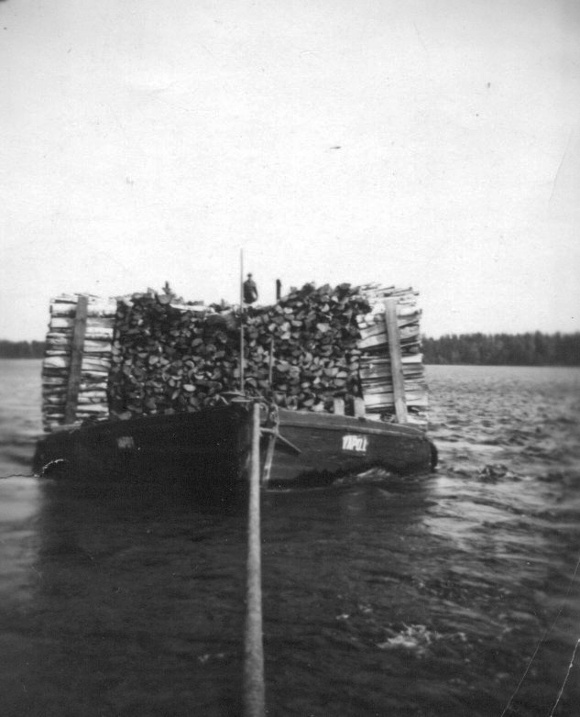 Höyrylaiva hinaa halkolastissa olevaa proomua Keiteleellä.