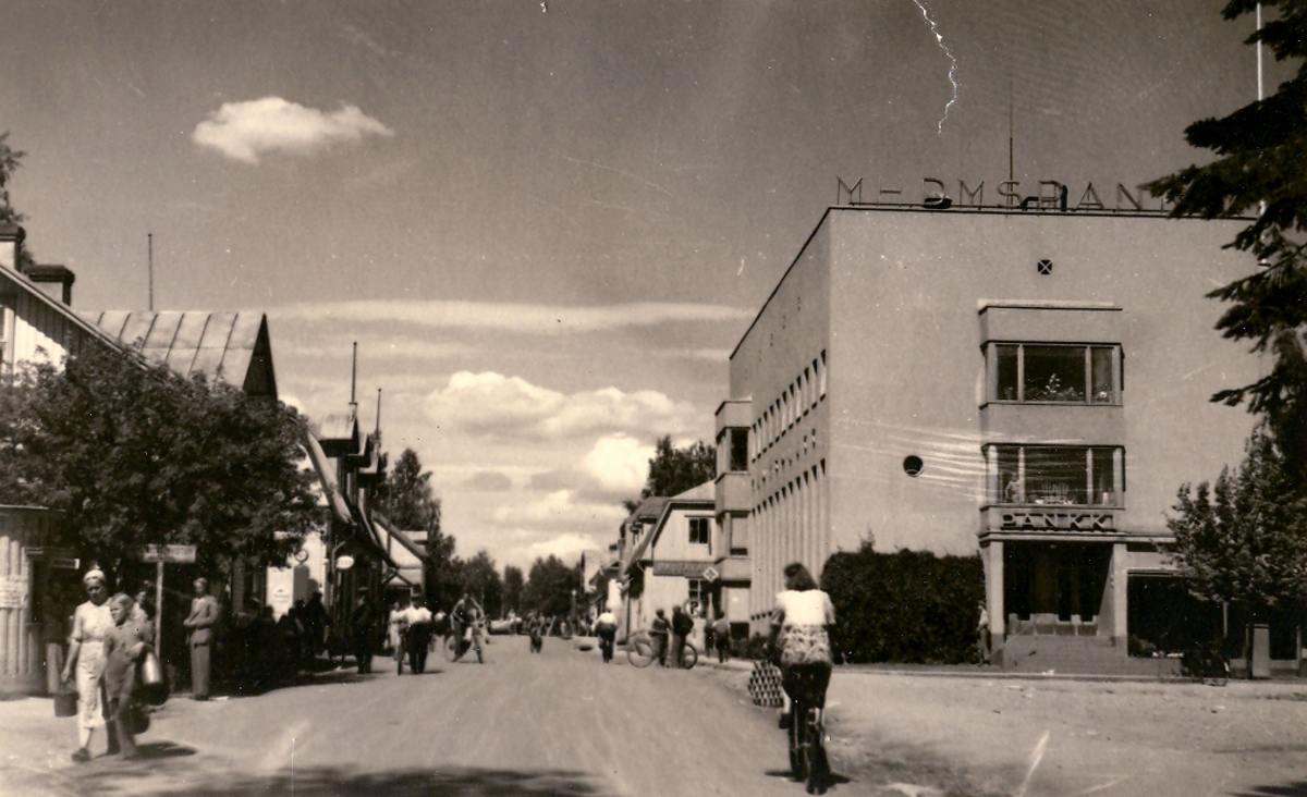 Äänekosken ensimmäinen taksitolppa sijaitsi Matkailijakoti Puuraan menevän kujan varrella 1937. Seuraavana vuonna se siirrettiin silloisen torin reunalle lähelle nykyistä Nordean rakennusta. Kolmas taksiasema sijaitsi Kuntalan edustalla vastapäätä Pohjoismaiden yhdyspankin 1939 rakennettua liikerakennusta. Kuvassa Yhdyspankin rakennusta ja sen ympäristöä vuonna 1940.