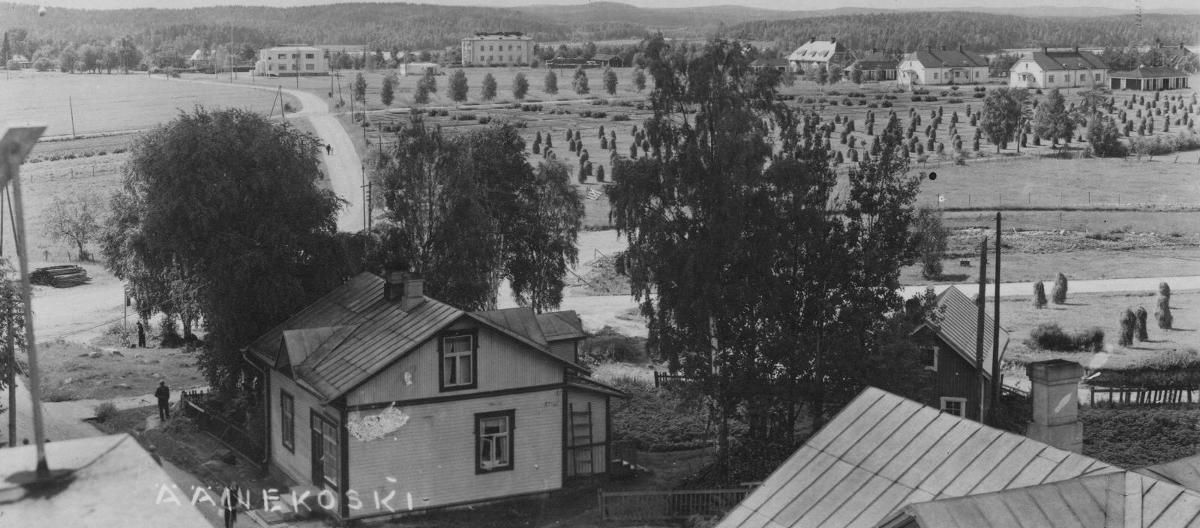 Äänekosken keskustaa nykyisten liikennevalojen tietämiltä etelän suuntaan 1930-luvulla. Etuvasemmalla oleva rakennus on Kummun Maijan kahvila. Taustalla näkyvä vaalea rakennus on 1928 valmistunut Äänekosken sairaala ja sen vasemmalla puolella nykyinen Piilolan päiväkodin rakennus. Oikeassa reunassa ovat nykyisen Terveyskadun varrella olevat kiviset tehtaan virkailijoille rakennetut pienkerrostalot. Alunperin ne rakennettiin yksikerroksisiksi, mutta myöhemmin niihin tehtiin myös yläkertaan asunnot. Topian pellolla nykyisen Lidl'n kaupparakennuksen paikalla on heinäpelto ja siitä vasemmalle nykyisen Kalle Piilosen patsaan tietämillä sijaitsi hyvä vesilähde, josta mm. Topialaiset kävivät hakemassa juomavetensä. Kummun kahvila hävisi Viiskulmasta 1940-luvun lopussa, jolloin rautatien ja postitalon rakentaminen muuttivat aluetta. Postitalo valmistui entisen Kotisuon reunamaalle 1952 ja rautatien ylittävän Soihtusillan vihkijäisiä vietettiin 14.7.1952.