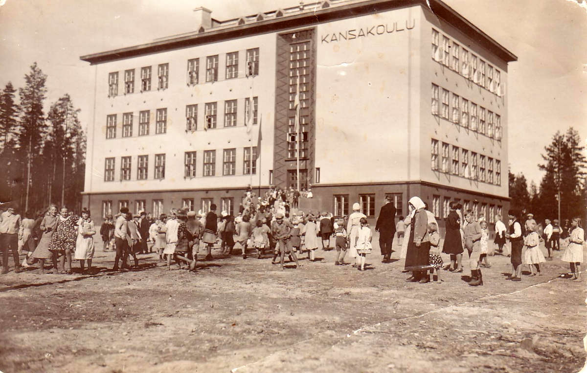 Kesällä 1931 valmistui Oppikankaan tontille arkkitehti Toivo Salervon piirtämä uusi kansakoulurakennus. Se piti sisällään kymmenen varsinaista luokkahuonetta, käsityö- ja voimistelusalit pinta-aloiltaan 58,5 m2 ja 112,5 m2 sekä pihaa noin 5370 m2. Lisäksi oli erikoisluokat luonnonoppia ja musiikkia varten sekä avara juhlasali, johtajaopettajan ja vahtimestarin asunnot. Koulutyö alkoi uusissa tiloissa 28.8.1931, jolloin oppilaita oli 442 ja opettajia kymmenen. Koulun vihkiäiset olivat 29.11.1931. Vuoden 1932 alusta lukien oppilaitos sai nimekseen Äänekosken kauppalan kansakoulu. Etualalla oleva huivipäinen nainen on Selma Suojanen ja hänen vasemmalla puolellaan selin oleva mies todennäköisesti J.A. Leppämäki.