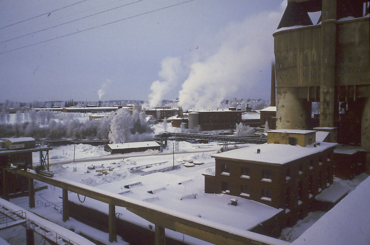 Sulfiitin happotorni ja sen edessä kuorimo ja hakkuosasto 1980-luvun alkussa.