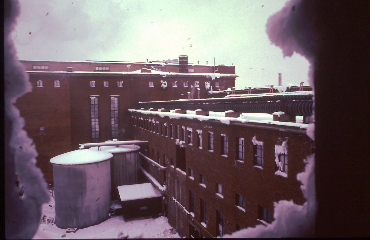 Taustalla sulfiitin keittömä. Kuvasta näkee hyvin, että keittömöä on laajennettu kahteen otteeseen tehtaan toiminnan aikana. Molemmat laajennukset ovat hieman alkuperäisestä väristä poikkeavia.