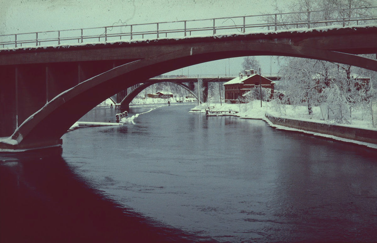 Taustalla Hiskinmäem saunarakennus ja etualalla vanhaa padottua koskiuomaa. Saunarakennuksen edessä näkyy 1900-luvun taitteessa  padotun koskiuoman patolaitteiden jäänteitä.