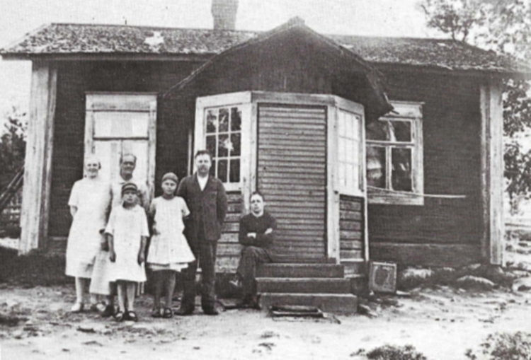 Suutari Lahti perheineen mökkinsä edustalla Pukkimäellä 1920-luvun alussa. Myöhemmin suutari laajensi mökkiään ja perusti siihen jalkineliikkeen. Sittemmin talo tunnettiin Pukkimäellä nimellä Carlssonin talo.