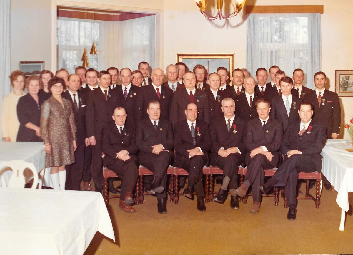 Palvelusvuosimitallien jakojuhlassa Piilolan klubilla 1970-luvulla. Kuvasta löytyvät ainakin Senni Heimonen, Ensio Kuha, Matti Kalenius, Tauno Tarvainen, Pastinen Martti, Aarno Hämäläinen, Eino Rahikainen, Uuno Hänninen, Paavo Pajari, Heikki Hytönen, Kalevi Kumpulainen, Seppo Ihanainen ja Kauko Saarinen.