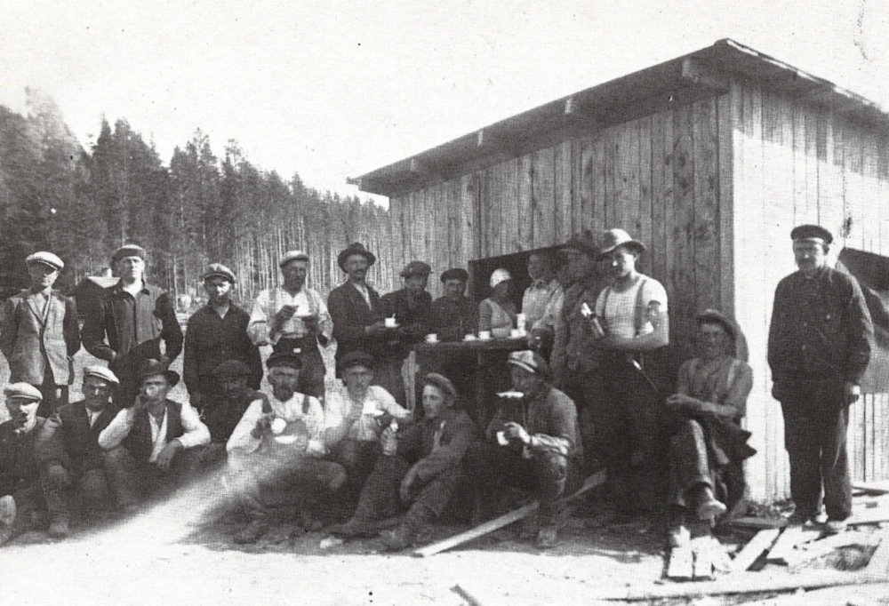 Hanna Korhonen vasemmalla ja Elvi Puttonen möivät tästä kojusta kahvia ja virvokkeita Äänekosken tehtaiden sahanrakentajille vuonna 1928. Kuvassa työmiehet ovat ryhmittyneet luukusta näkyvien myyjättärien ympärille. Tehtaita uusittiin koko 1920- ja 1930-luvun ajan ja enimmillään rakennusmiesten lukumäärä tehtailla nousi yli 350:een.