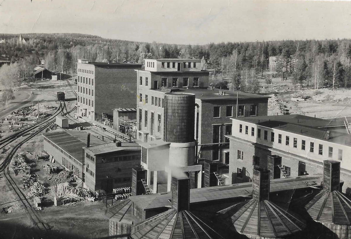 Kemiallisen tehtaan rakennuskantaa 1950-luvulla. Sulfiittispriitehdas käynnistyi sota-aikana 1942 ja kemiallisen tehtaan rakentaminen seuraavana vuonna 1943. Etualalla ilmeisesti sulfiitin keittohapposäiliöitä. Oikealla ylhäällä Hiskinmäen 1960-luvun puolivälissä purettu yhteiskoulun puurakennus.